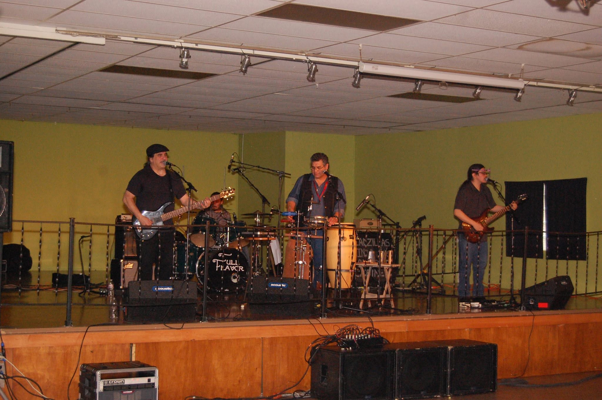 A band with guitars and congas playing on the hall stage