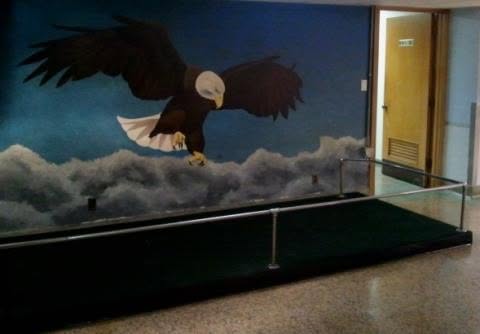 The painted eagle mural inside the club, beside the ramp and handrail into the lower hall