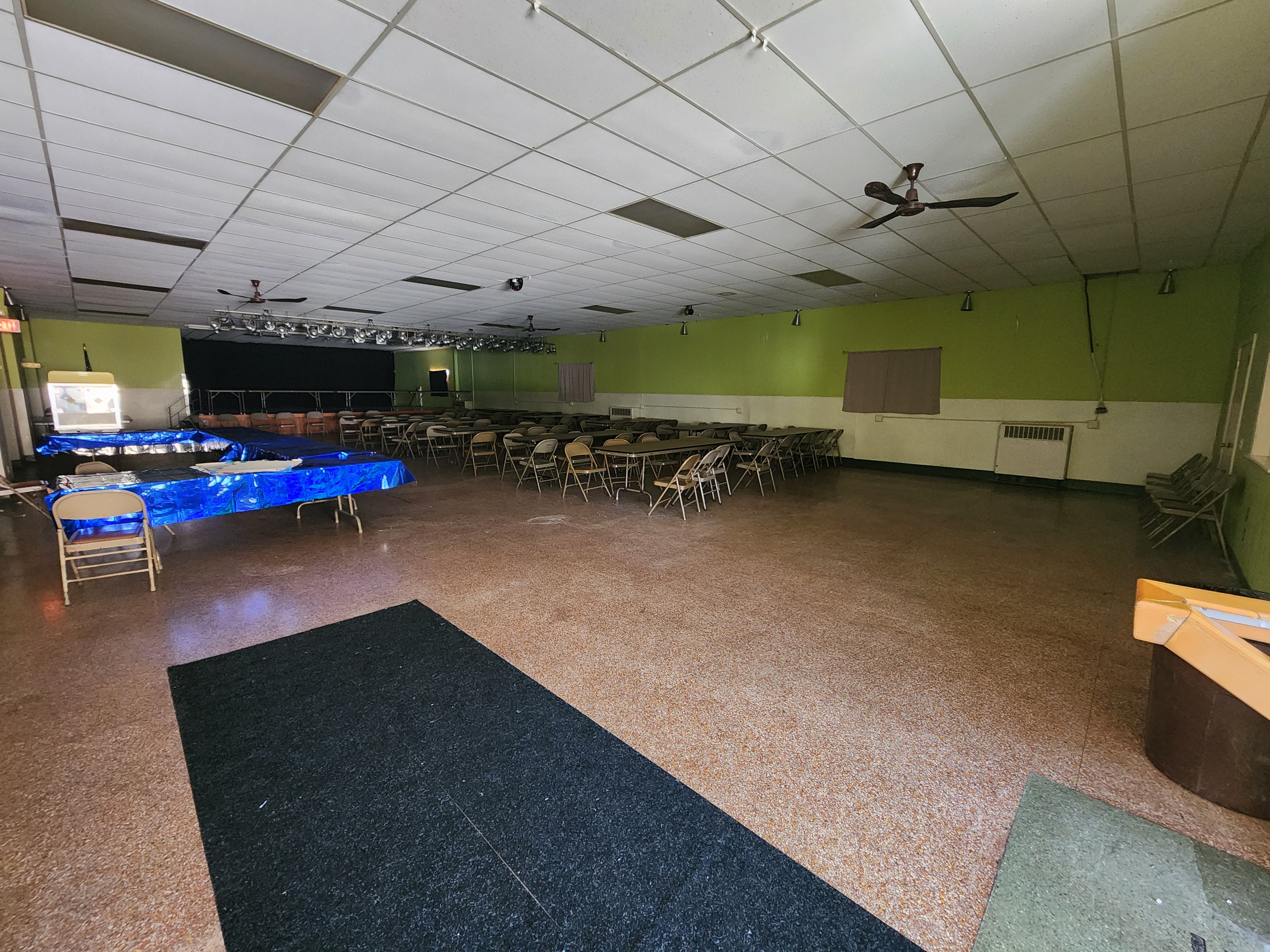The upper hall laid out with serving tables in the foreground and seating running back towards the stage